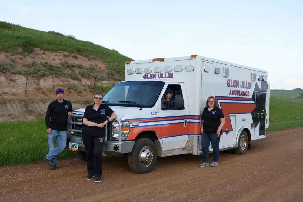 Glen Ullin Ambulance Service EMTs Wade Kottre (from left), Lori Kottre, Dwight Kuntz, and Rita Wallin pose for a portrait on a county road in Glen Ullin, North Dakota. 