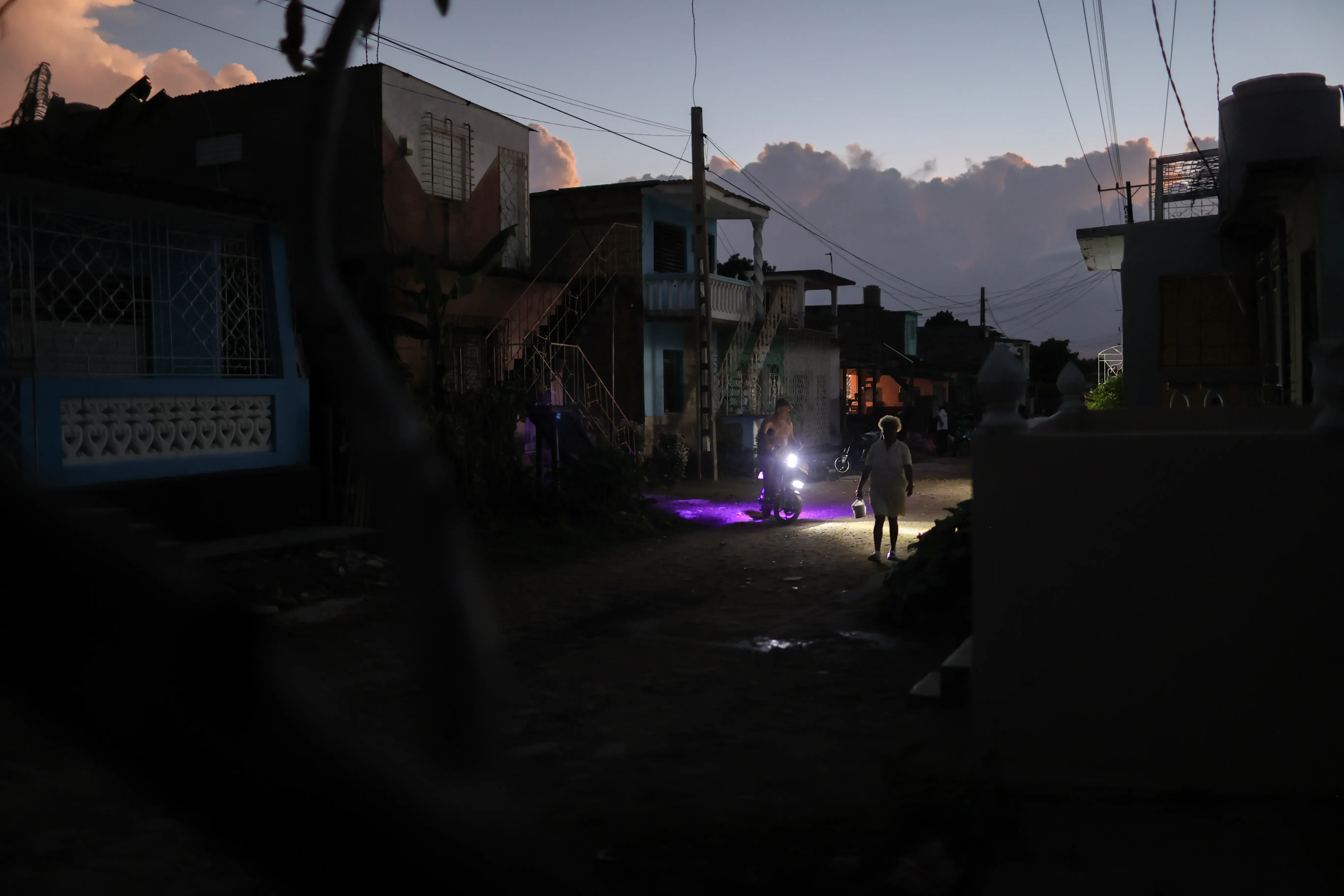 In a suburb on the outskirts of the city of Camaguey, people rush home after sunset. Photo : Luis Bustamante 