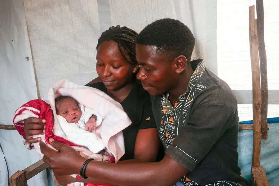 A man and woman hold their newborn son