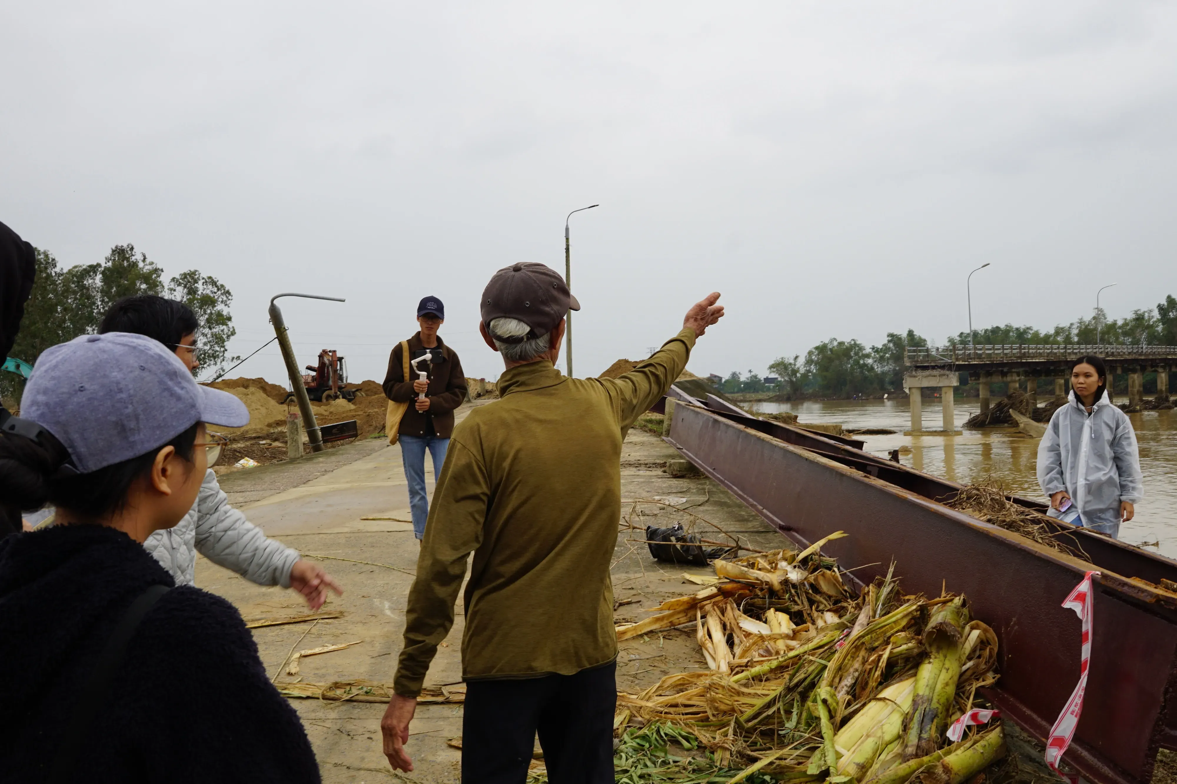 A site visit to a collapsed bridge to analyze the harsh reality of “erosion vs. deposition" and the failure of rigid concrete vs. soft-embankment ecosystems. Image courtesy of the Thì Collective.