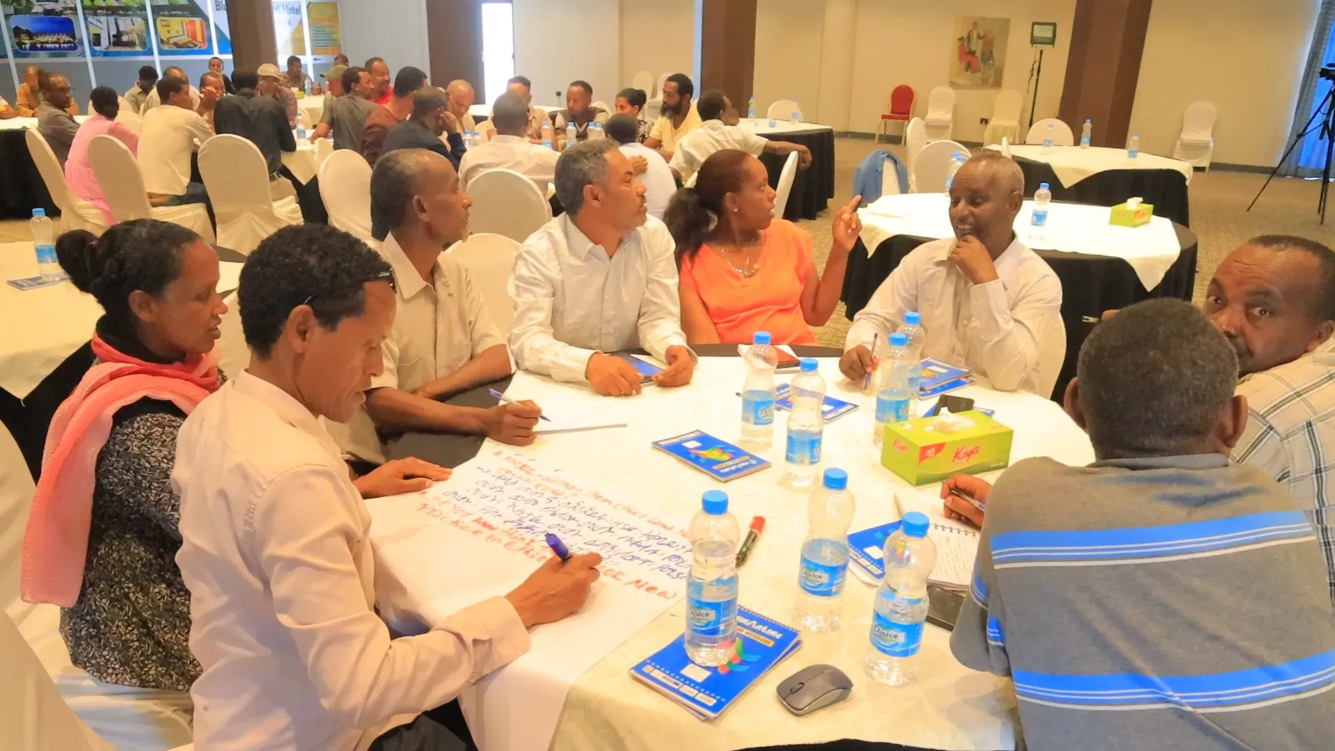 Participants sitting at a table and engaging in group discussions