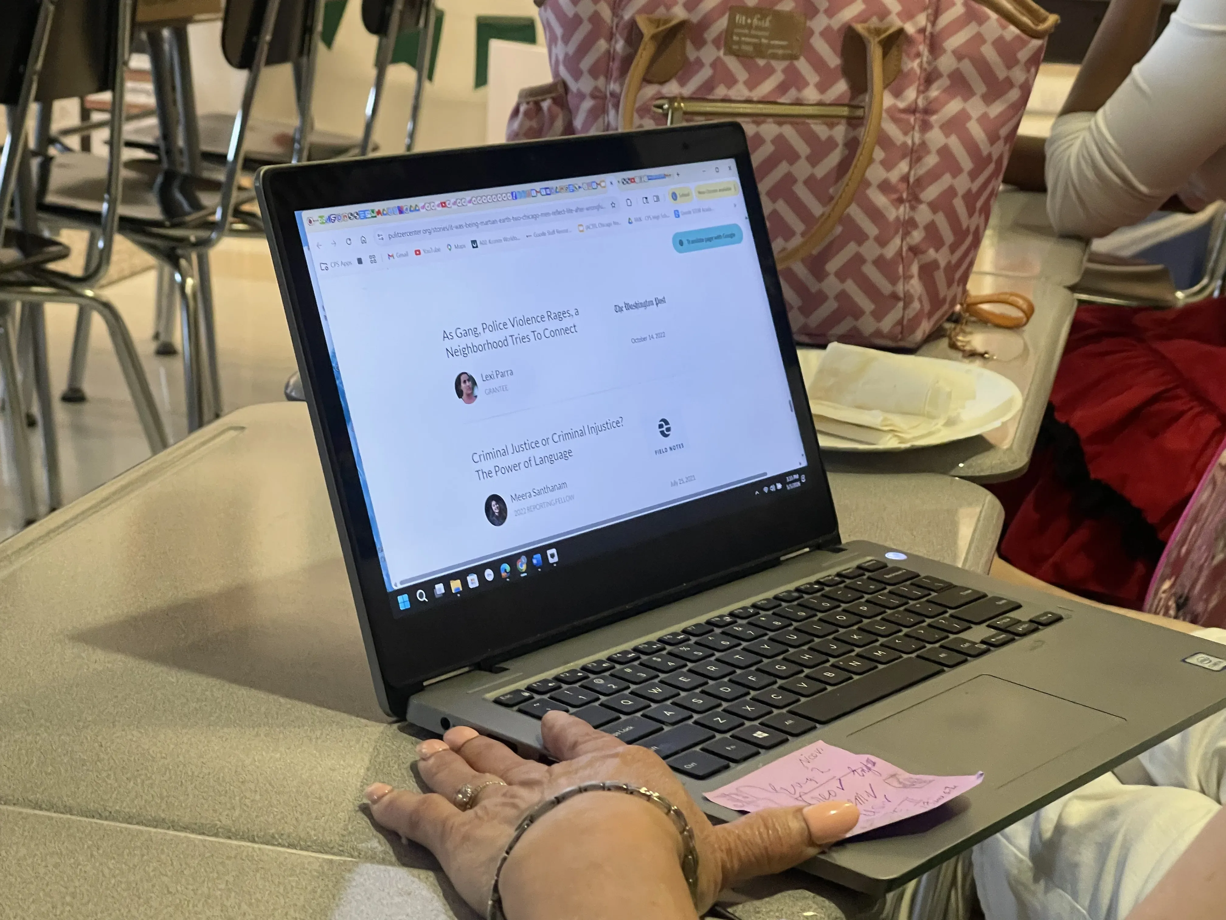 a laptop screen on a school desk shows someone browsing the pulitzer center website