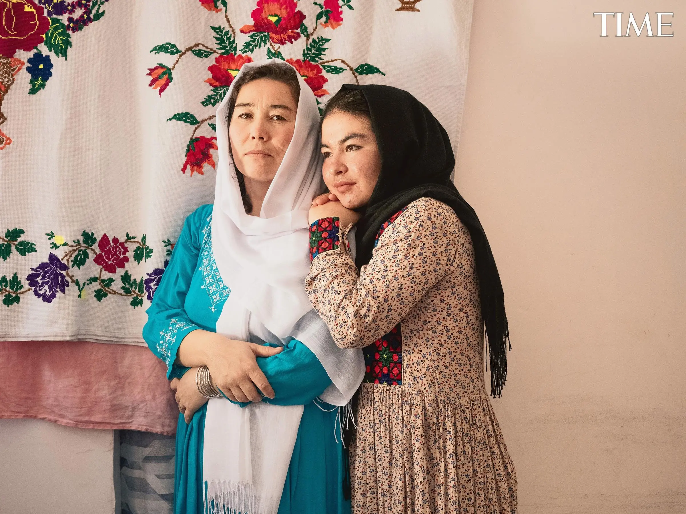 An Afghan woman and her daughter embrace.