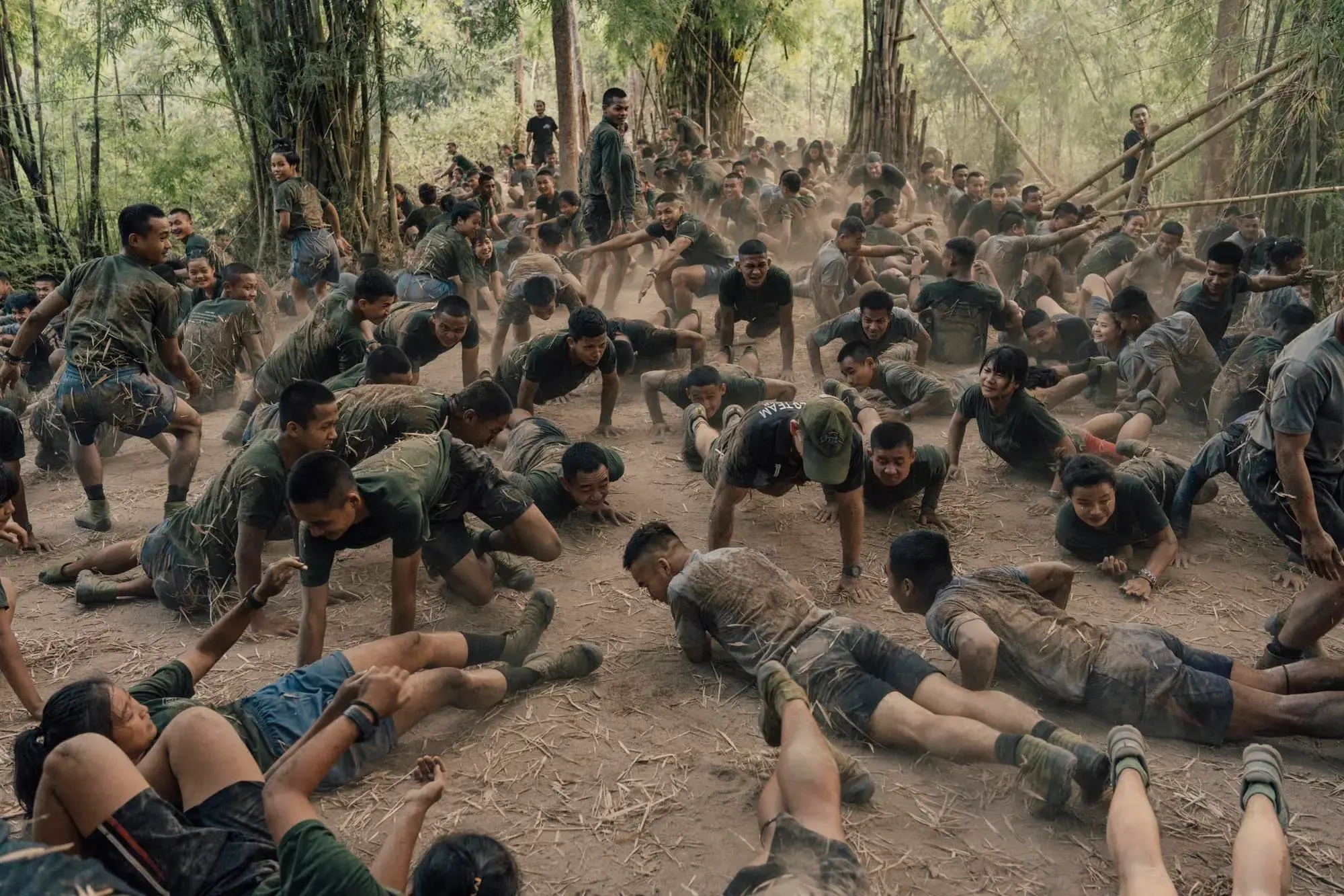 Trainees go through a pushup session as part of a “Ranger Run” they must complete to graduate. They are covered in dirt and dust