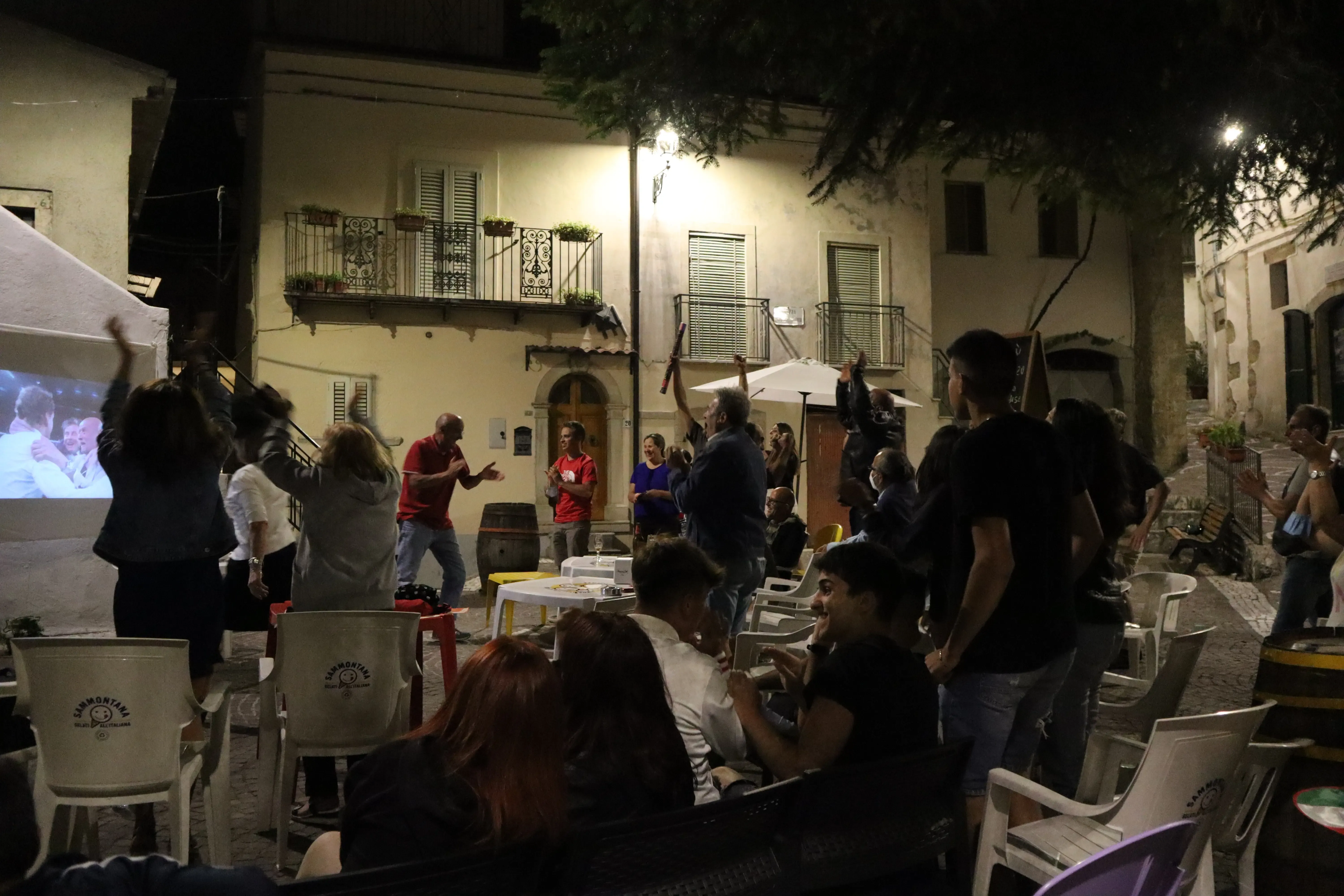 People in town celebrate a soccer match win, people are jumping 