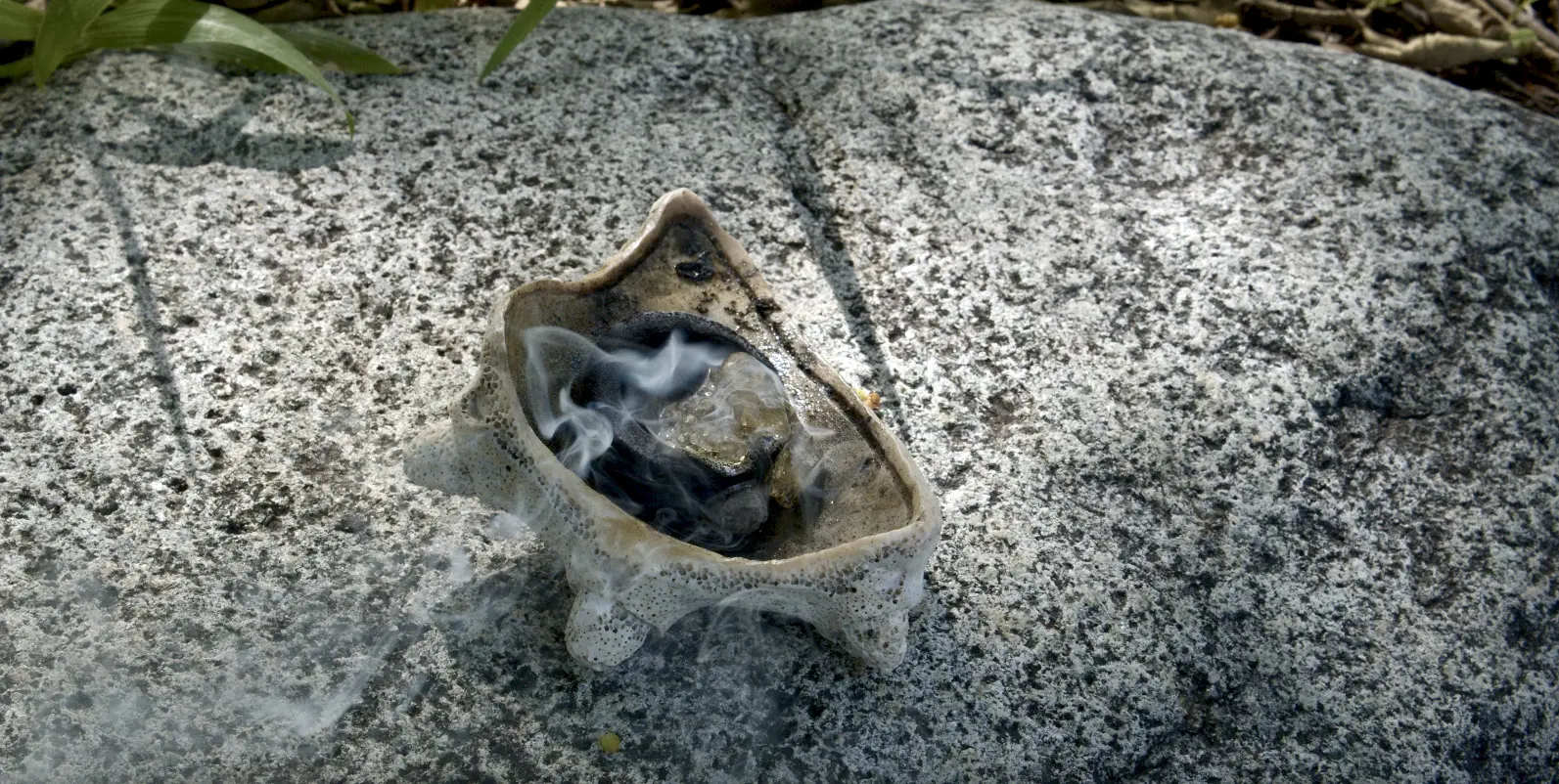 Smoke billows from a carved out conch shell