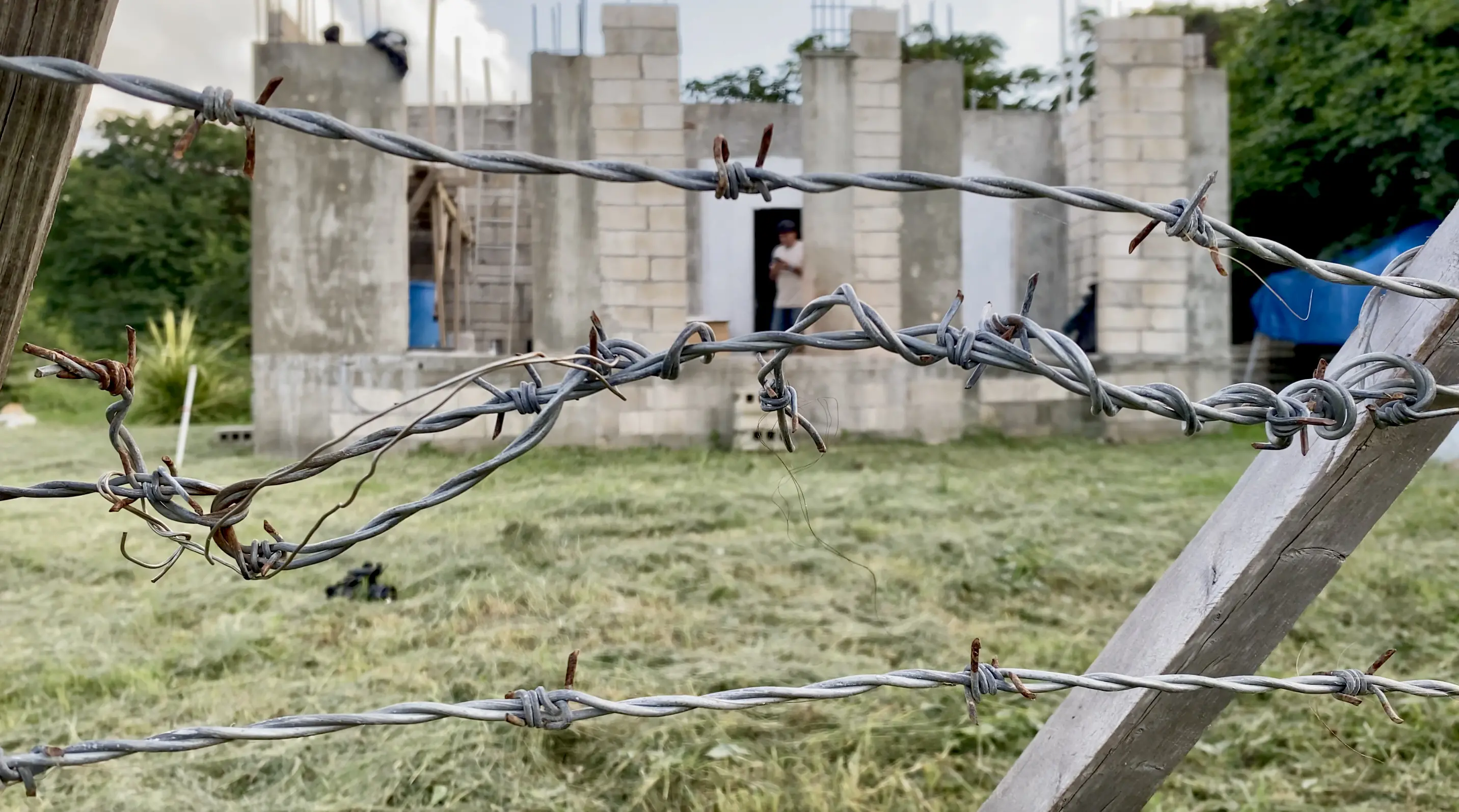 barbed wire in front of concrete foundation