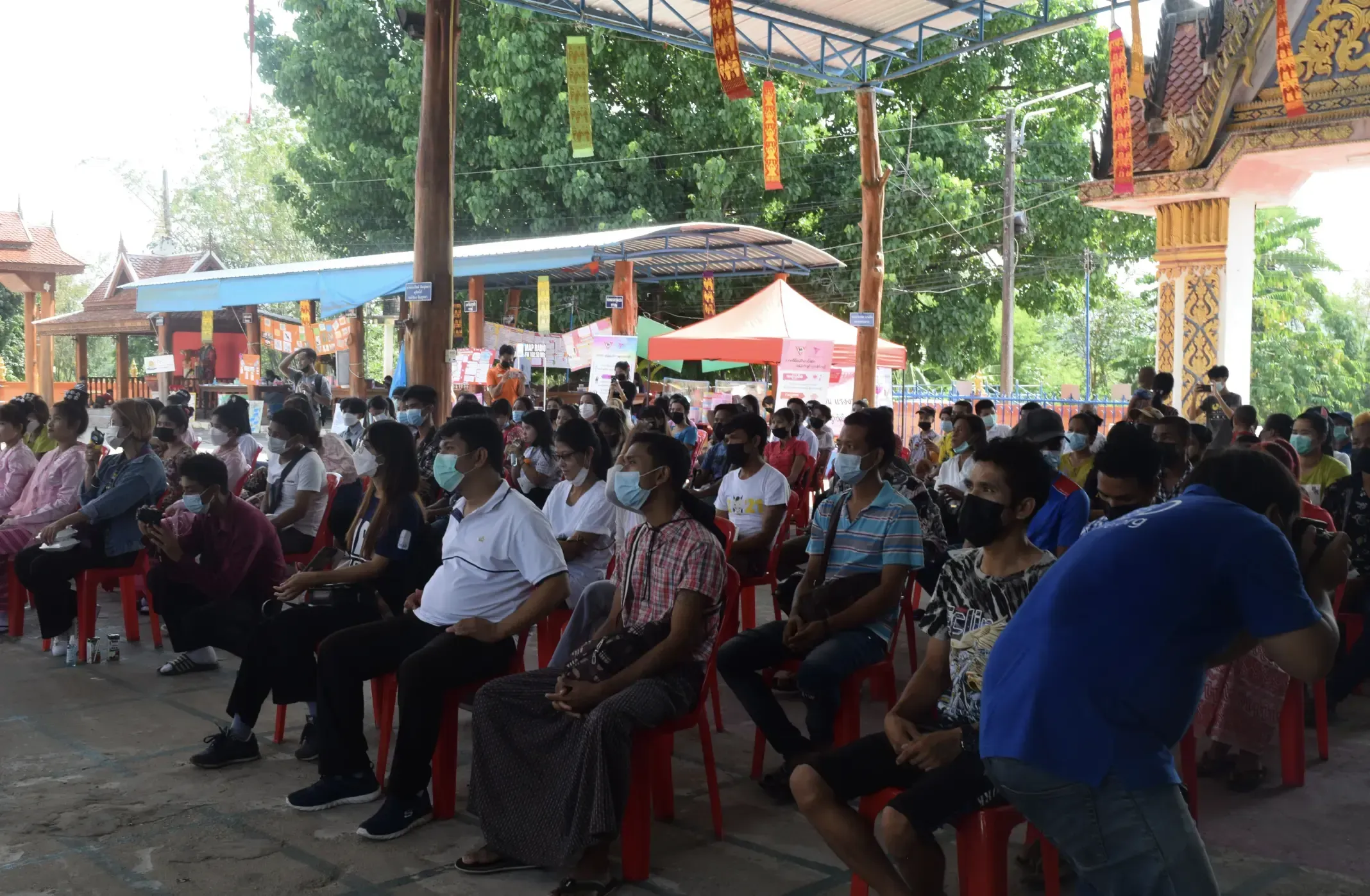 Workers sit masked on chairs listening to a talk from an NGO about workers rights