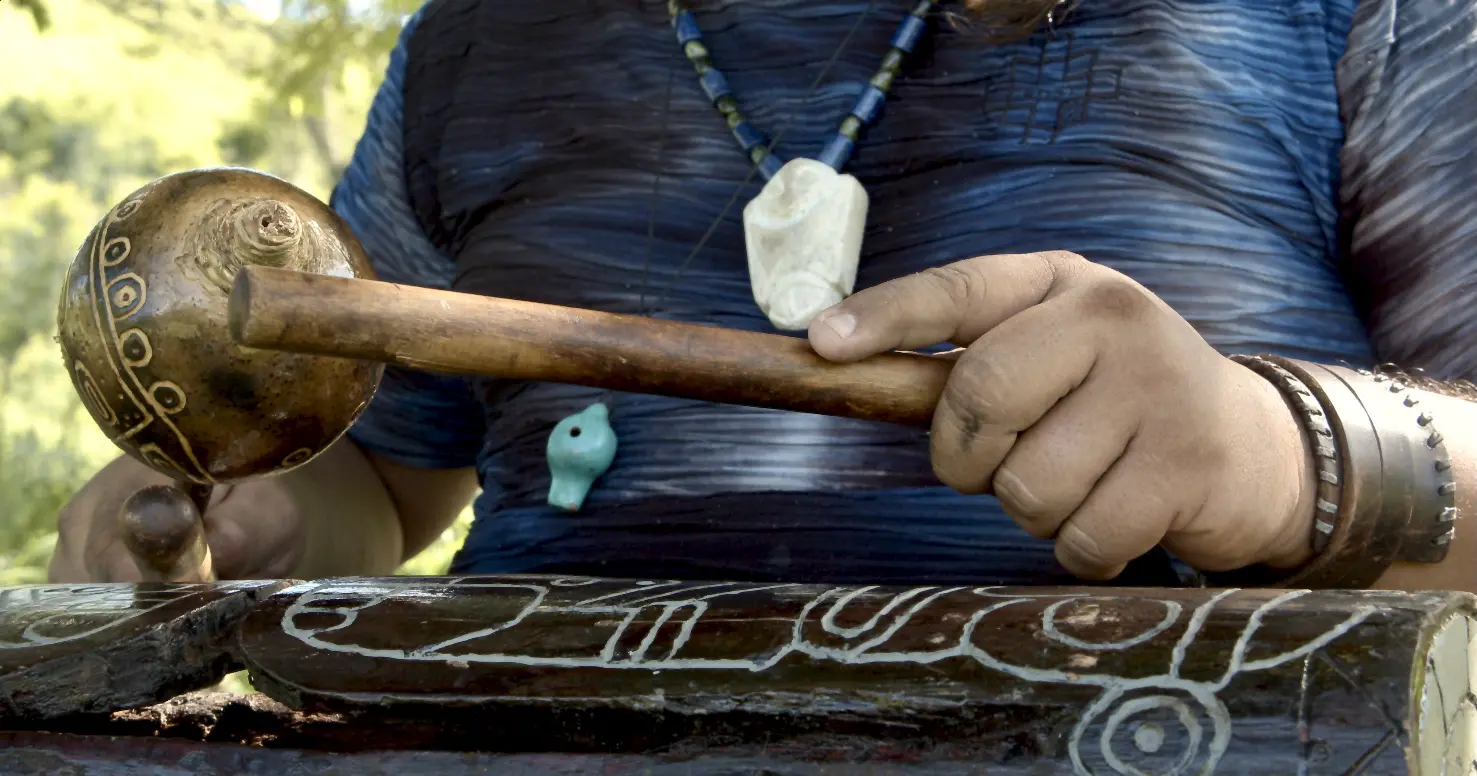Po Araní plays a steady beat on the mayohuacan with a maraca in hand