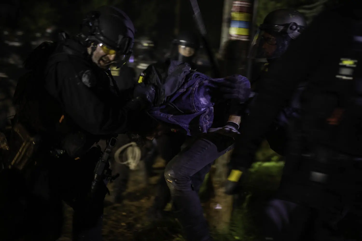 A group of police officers grab a protester.