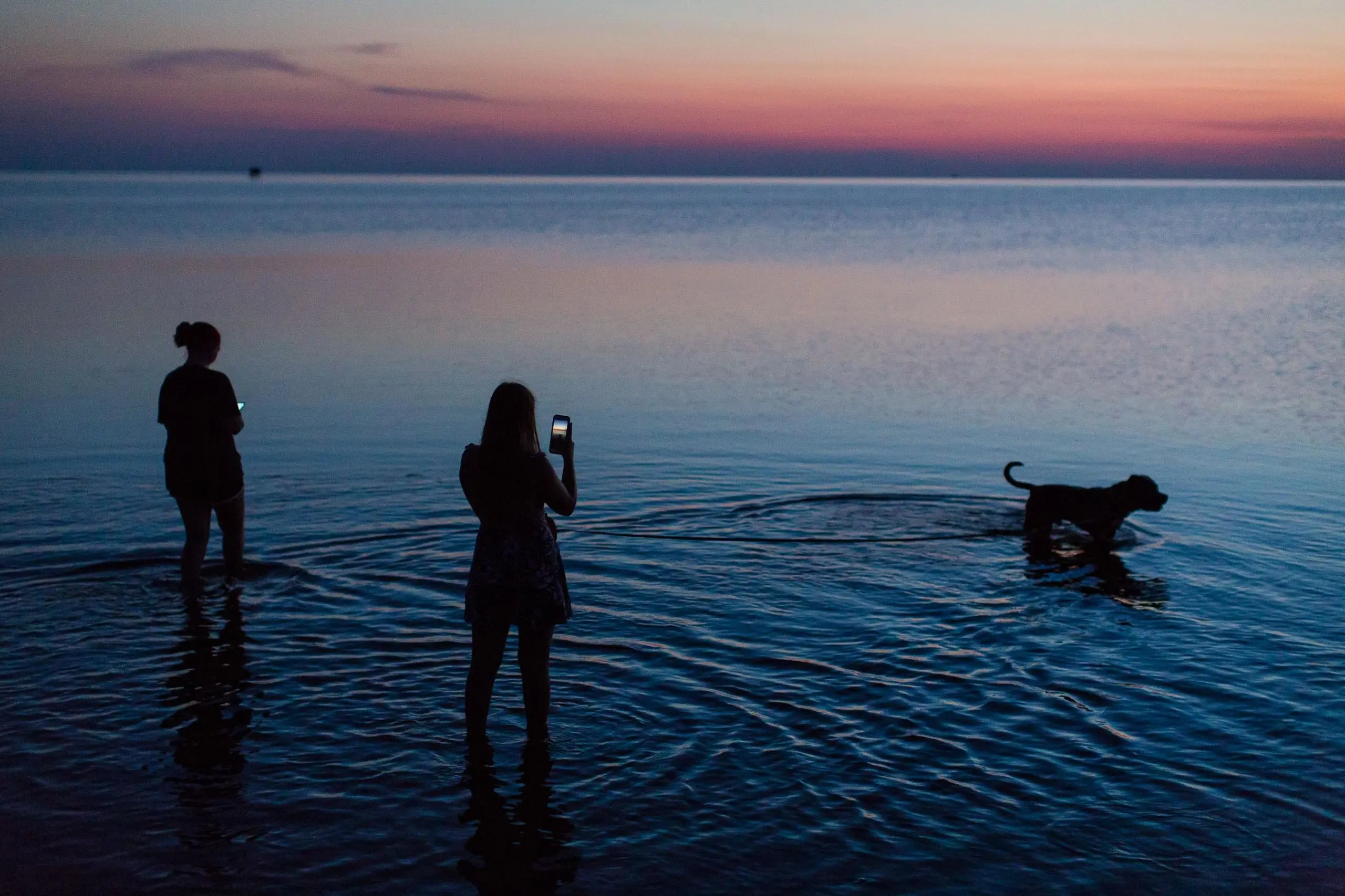 Woman takes photo of sunset