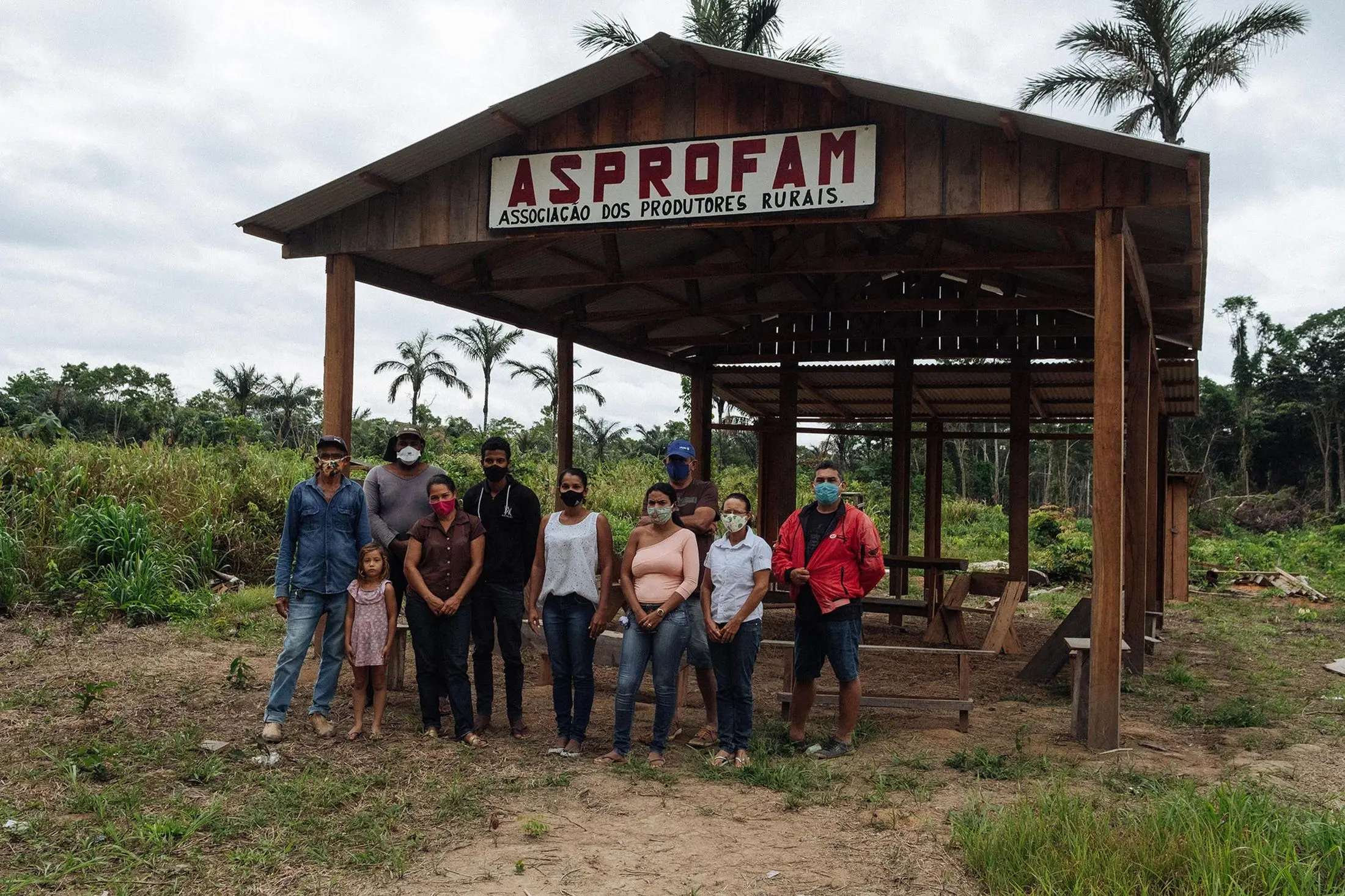 Settlers stand in front of rainforest