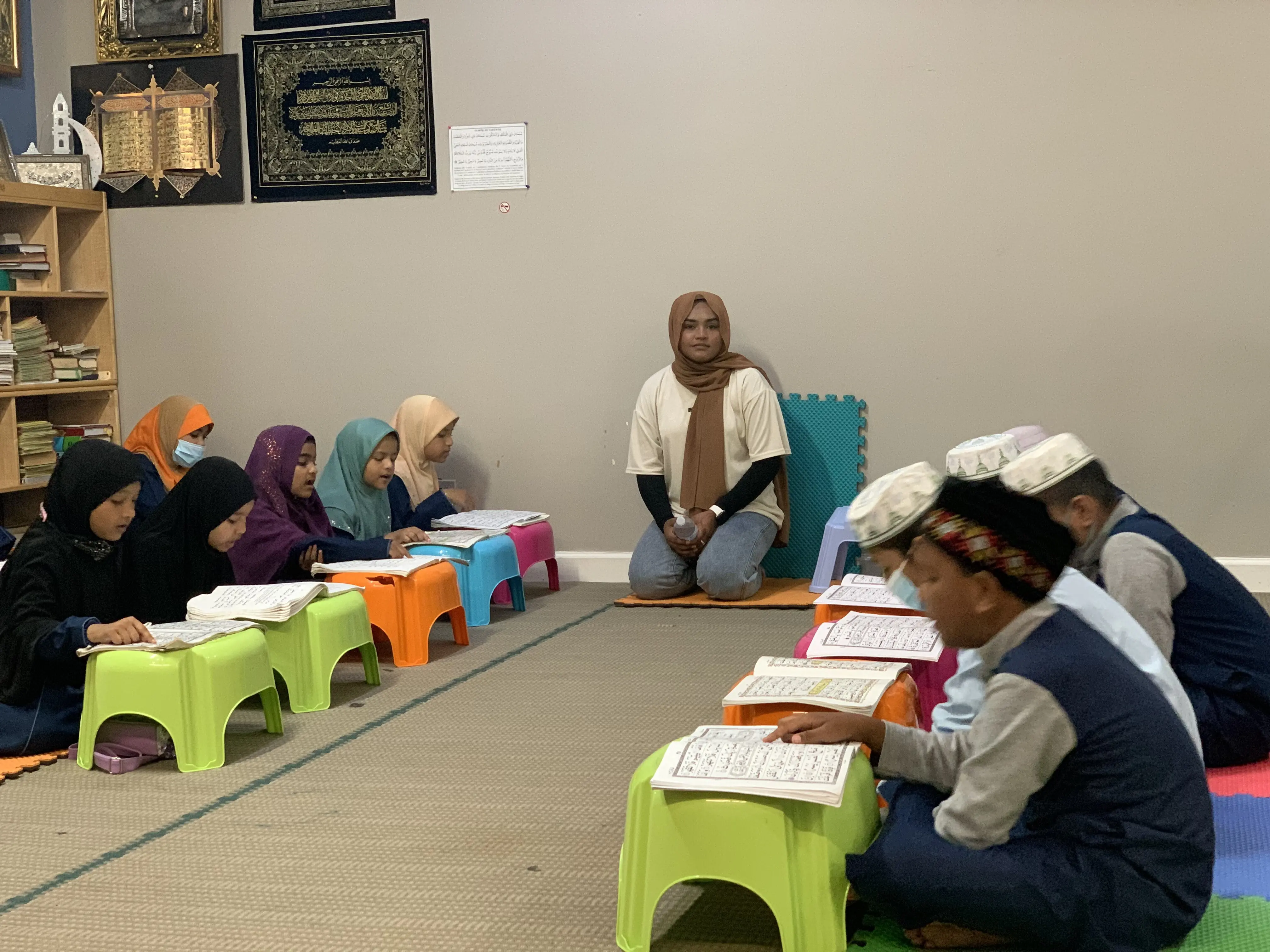 Rohingya children seated alongside their teacher