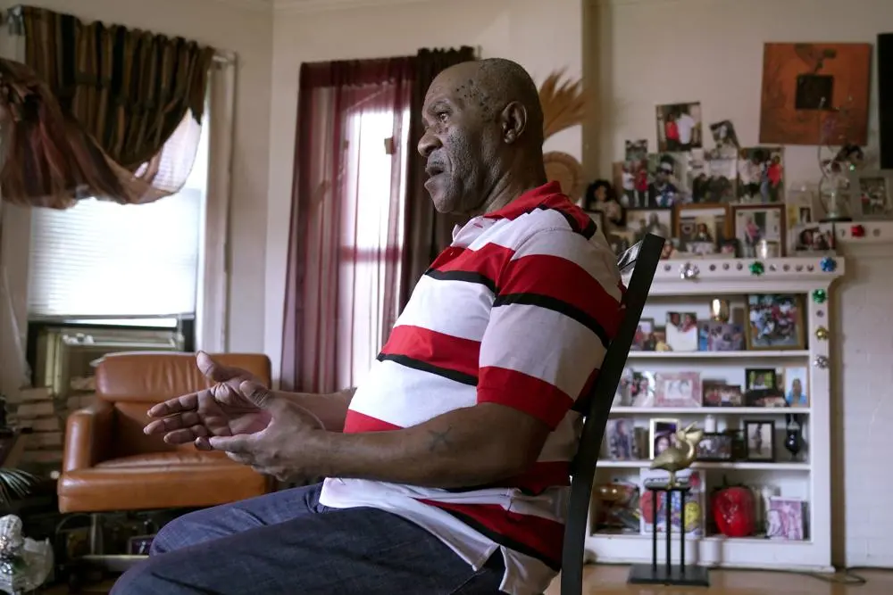 Man sits in chair in his home