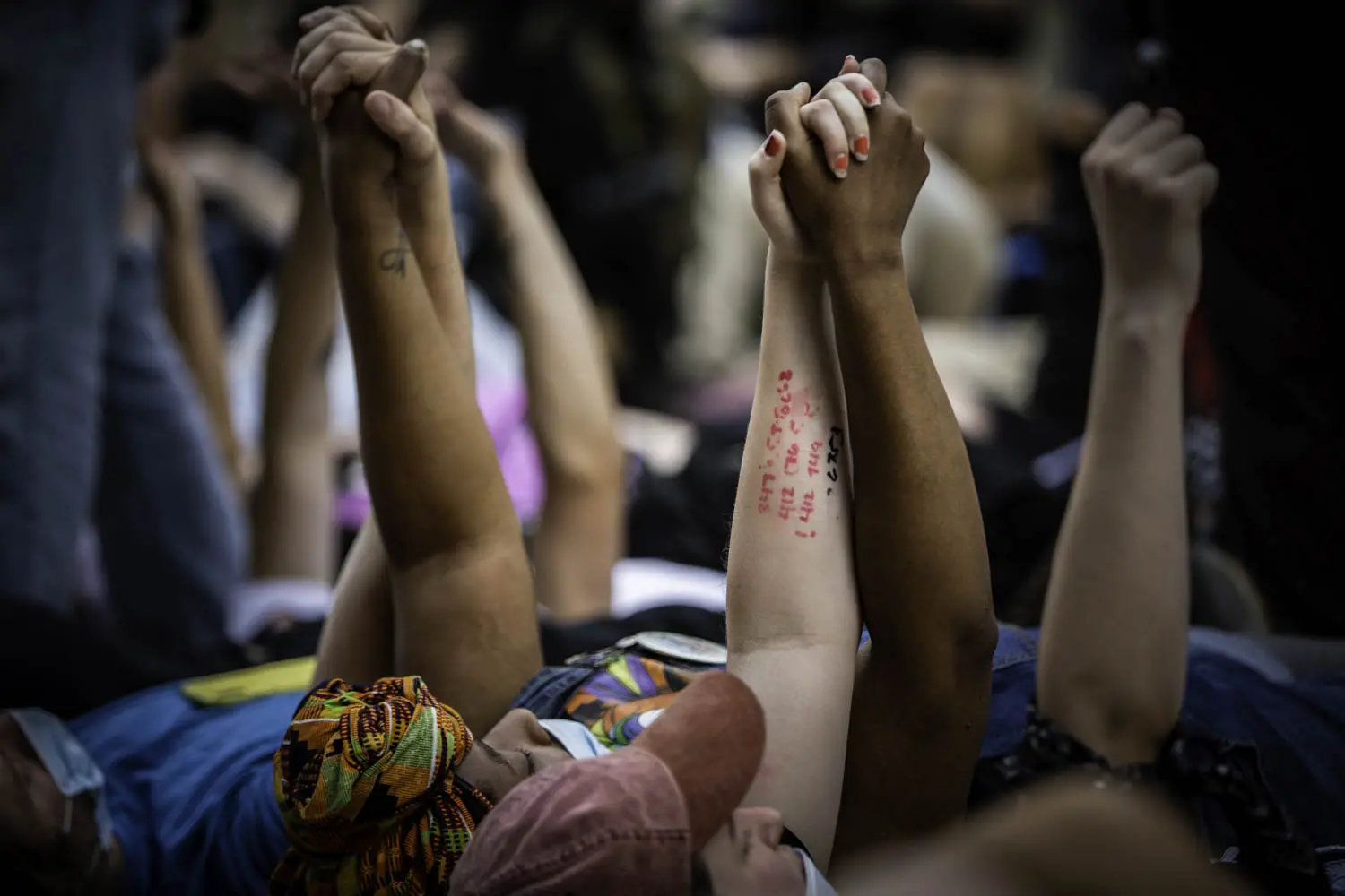 People raise joined hands during a protest.