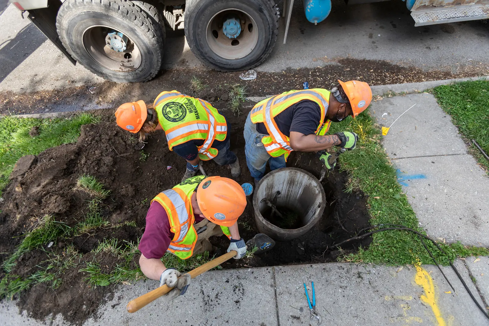 Employees of the Chicago Department of Water Management work on replacing a metered water vault in Woodlawn