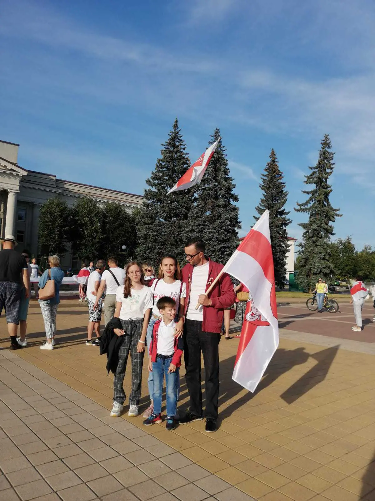 man stands with flag and family