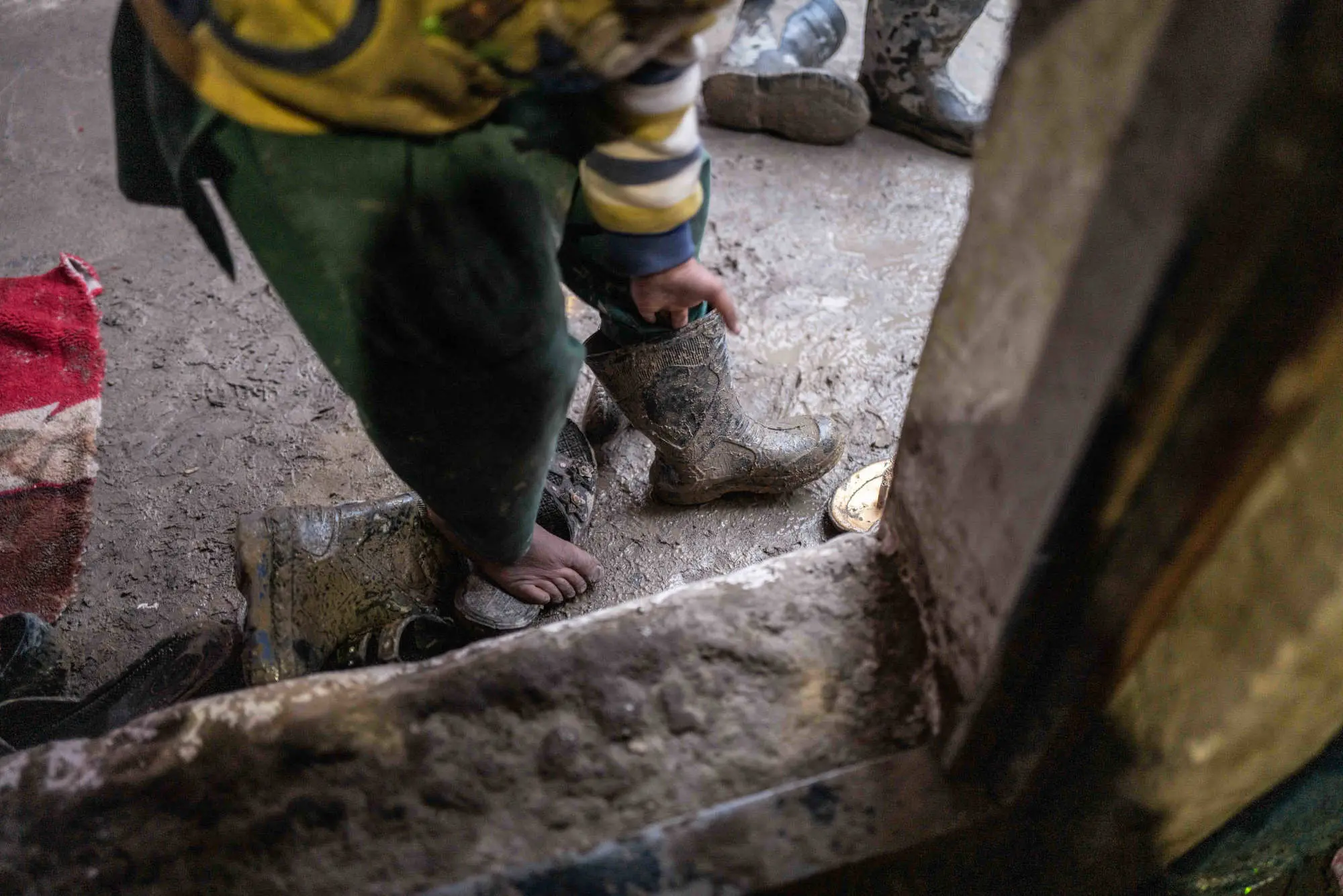 A man takes a muddy boot off