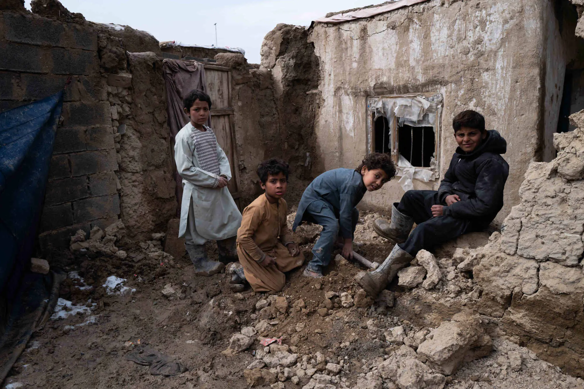 Four young boys sit on rocks