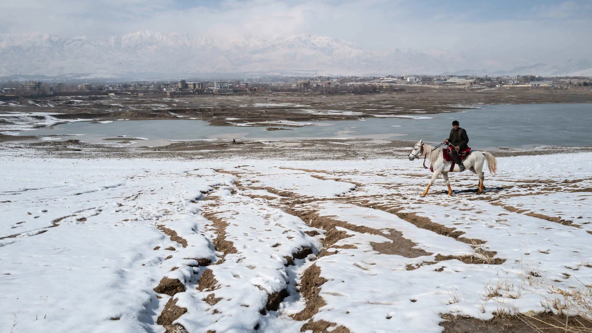 A man rides a horse over a snowy landscape