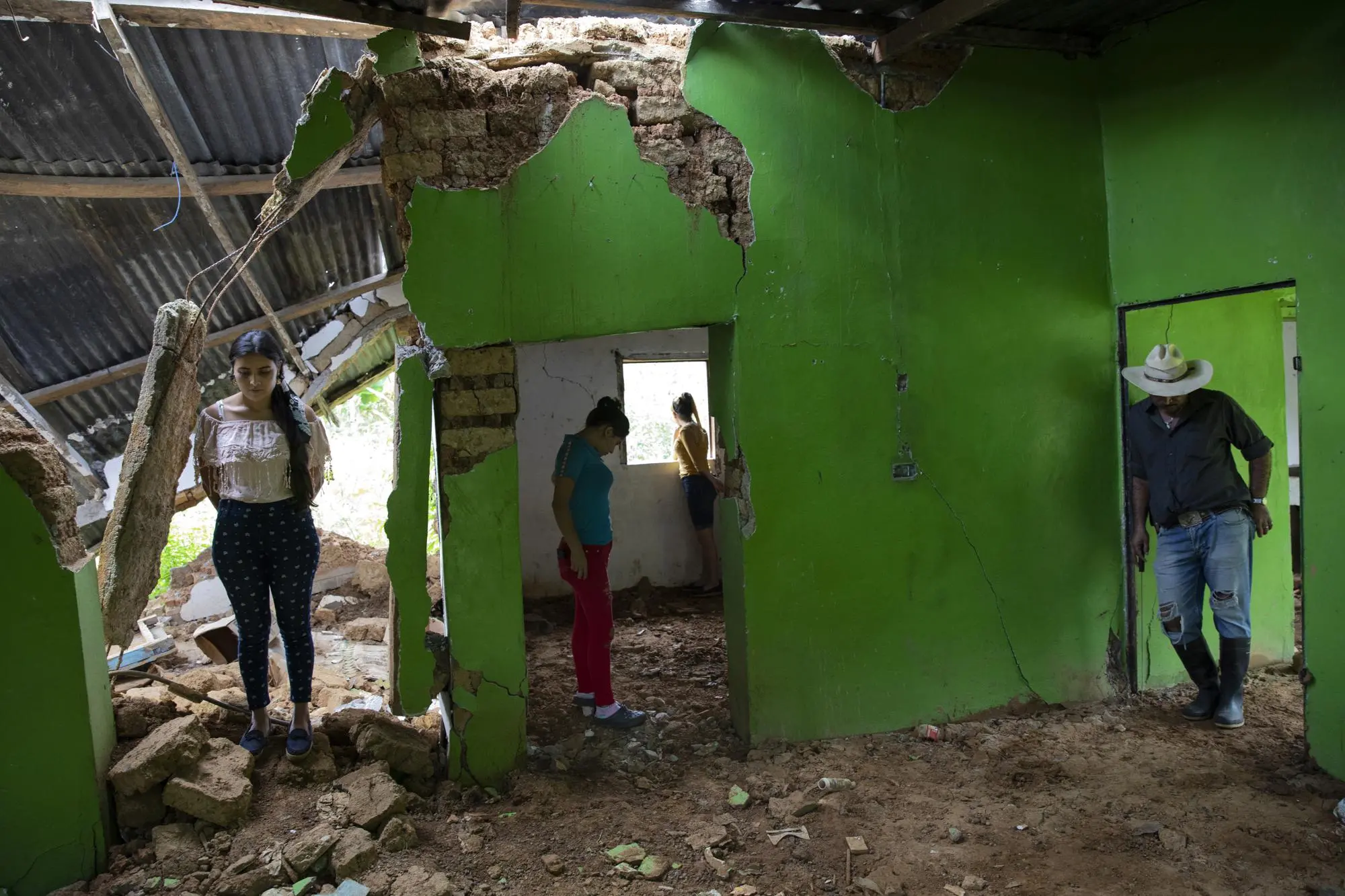A family stands where there home used to be