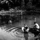 WATER SOURCE.&nbsp;Santi takes a bath in the murky water with a neighbor while her mother Ida washes their clothes. The reservoir is the community's only source of water. Image by Xyza Cruz Bacani. Indonesia, 2018.&nbsp;