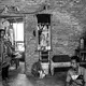 AFTER A DAY'S LABOR.&nbsp;Ida tries to comfort her daughter Santi while her husband Supriyono sits on the floor after a day's work. The gallon jugs of water in the corner are their only water for two weeks. They pay 56,000 Rupiah ($3.84) per gallon. Image by Xyza Cruz Bacani. Indonesia, 2018.