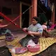 Maria de Jesus Lopez Pérez, 62, (center) is the matriarch of a clan of weavers living in a cramped compound in San Antonio Aguas Calientes. To provide the family of 45 with a normal Sunday meal, all the women hover around fires in one corner of the compound. Image by Lynn Johnson. Guatemala, 2017.