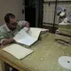 Archivist Oscar Hernández, left, cleans and sorts a file of documents concerning police detention of children and minors in the 1980s. Hernández, 34, was a young boy when his father was abducted by the National Police. In the course of his daily work at the archive, he has discovered some clues to his father’s disappearance, but he may never know the full story. Image by Lynn Johnson. Guatemala, 2017.