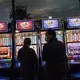 People stand in front of electronic slot machines in a Casino in Las Vegas, Monday, Nov. 9, 2020. Image by Wong Maye-E / AP Photo. United States, 2020.