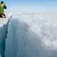 University of Montana glaciologist Joel Harper examines a deep crack in the ice sheet called a crevasse. Image by Amy Martin. Greenland, 2018. 