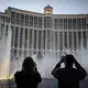 People are silhouetted as they take photos of the fountains at the Bellagio hotel-casino along the Las Vegas Strip, Wednesday, Nov. 11, 2020. Image by Wong Maye-E / AP Photo. United States, 2020.