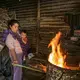 Near Antigua Guatemala, eight-month-old Pablito keeps an eye on breakfast as his mother, Angélica Epatal Garcia, tends to the makeshift barrel stove. She and her daughters walk 45 minutes each way to collect the wood for three daily fires. Image by Lynn Johnson. Guatemala, 2017.