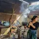 The new yellow stove is efficient, but the old open fire is better for the giant pot in Etelvina Pérez's kitchen in San Antonio Aguas Calientes. Image by Lynn Johnson. Guatemala, 2017.