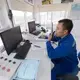 A worker monitors the blending of feed from an elevated control room at TH Milk's operations in Nghia Son, Vietnam. The company has 200 workers dedicated to the production of 500,000 tons of animal feed for their 40,000 head dairy operations. Image by Mark Hoffman. Vietnam, 2019. 