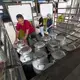 A farmer unloads milk cans from his small pickup truck at the Pakchong Dairy Cooperative in Pak Chong, Thailand. Image by Mark Hoffman. Thailand, 2019. 