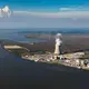 The nuclear disaster in Fukushima, Japan, in which a six-reactor compound was struck by a tsunami, proved the vulnerability of reactors to flooding. Three of the units were destroyed. Nine US nuclear power plants are within about three kilometers of the ocean. Independent experts consider four of them, including two shown here—the Hope Creek Generating Station (the cooling tower billowing a cloud of steam) and Salem Nuclear Generating Station (the double domes on the right) in Lower Alloways Creek Township, New Jersey—especially vulnerable to sea level rise and storm surges. Fortunately, the risk of a tsunami, though not zero, is considered low on the US east coast. Image by Alex MacLean. United States, 2019.