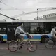 A woman rides a rental bike through an intersection on Wednesday, Sept. 27, 2017, in Beijing. Bikes and scooters have become a popular means of transportation in the large city where car traffic is always heavy. Image by Kelsey Kremer. China, 2017.