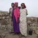 Sixteen-year old Ethiopian migrants from left, Safeya, Ikram, and Hamdiya, pose for a portrait, July 12, 2019, at a slum in Dikhil, Djibouti, where they took shelter after entering the country on their journey intended to take them to Yemen and Saudi Arabia. The 100-mile (120-kilometer) trip across Djibouti to the water can take days. Many migrants end up in the country's capital, living in slums and working to earn money for the crossing. Young women often are trapped in prostitution or enslaved as servants. Image by AP Photo / El-Mofty. Djibouti, 2019.