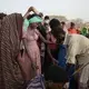Ethiopian Tigray migrants in Obock, Djibouti, stand in line to receive water brought by smugglers, as they take shelter under trees at the last stop of their journey before leaving by boat for Yemen in the evening, July 15, 2019. Image by AP Photo / Nariman El-Mofty. Djibouti, 2019.