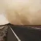 A sandstorm gusts, July 12, 2019, over a road about 50 kilometers (31 miles) from Djibouti, where African migrants walk en route to the shore and passage to Yemen with smugglers. Image by AP Photo / Nariman El-Mofty. Djibouti, 2019.