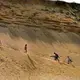 Beachgoers made the steep climb up a towering sand dune cliff from White Crest Beach to the parking lot above. Image by John Tlumacki. United States, 2019.