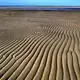 A couple walked along Chapin Beach as patterns formed on the sand at low tide. Image by John Tlumacki. United States, 2019.