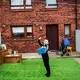 David Crichton plays on his iPad in the backyard of his home, where he has a sensory garden, in Possilpark. Image by Michael Santiago. United Kingdom, 2019.
