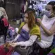 Hair salon owner Meyly Heng places a hair extension on a customer in Phnom Penh. Image by Paula Bronstein. Cambodia, 2019.