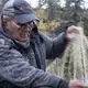 Gideon James checking his fishing net. Image by Amy Martin. United States, 2019.