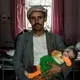 Ali Qasim al-Ajil holds his malnourished 6-month-old daughter, Kawthar. Image by Alex Potter. Yemen, 2018. 