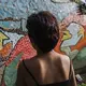 Sara in front of a mosaic she helped make with other survivors and members of Rise Up. Image by Pat Nabong. Philippines, 2017.