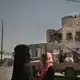 In this Feb. 12, 2018, photo, women walk past Saudi-led coalition backed forces, who are leading the campaign to take over Hodeida, as they patrol Mocha, a port city on the Red Sea coast of Yemen. Violence, famine and disease have ravished the country of some 28 million, which was already the Arab world’s poorest before the conflict began. The conflict pits a U.S.-backed, Saudi-led coalition supporting the internationally recognized government, which has nominally relocated to Aden but largely lives in exile, against rebels known as Houthis. Image by Nariman El-Mofty. Yemen, 2018. </p>
<p>