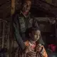 Workers like Mohammad Esarul Molla, 28, and his daughter Moumita, age 6, reside in huts on the factory property. While the air is often hard to breathe, the job is welcomed. Image by Larry C. Price. Bangladesh, 2018.